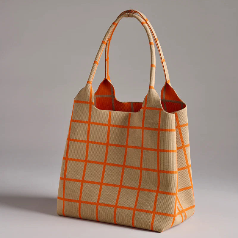 Knitted fabric tote bag featuring a vibrant orange windowpane grid pattern and textured ribbed weave displayed in a neutral studio setting