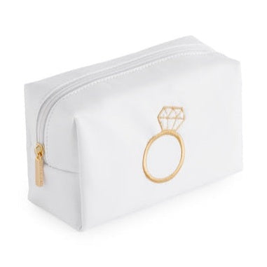 White vegan leather cosmetic bag by Katie Loxton featuring a gold embroidered diamond ring icon on the front with a matching gold-toned zipper and a boxy silhouette against a plain white background
