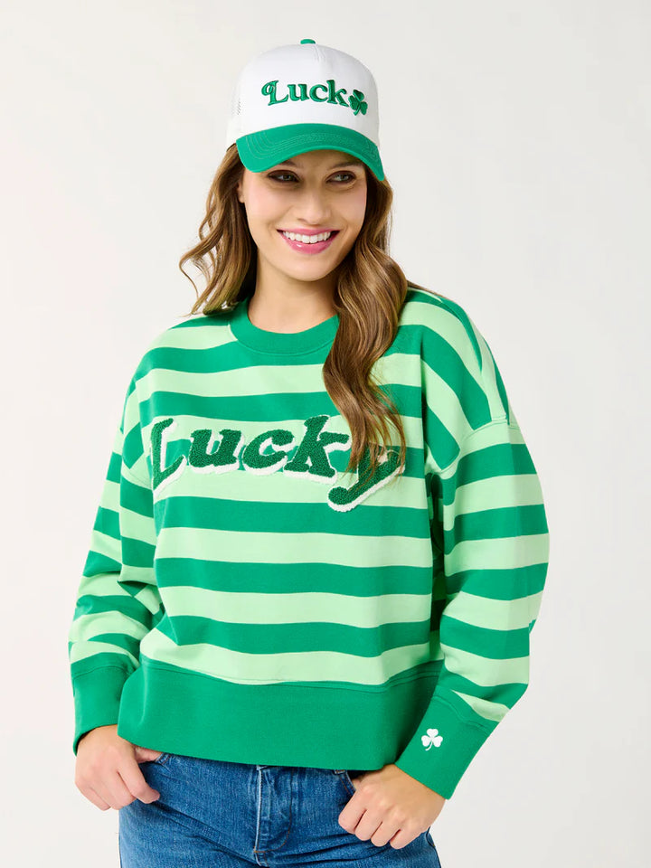 Digital photograph of a smiling woman in a studio wearing a St. Patrick&
