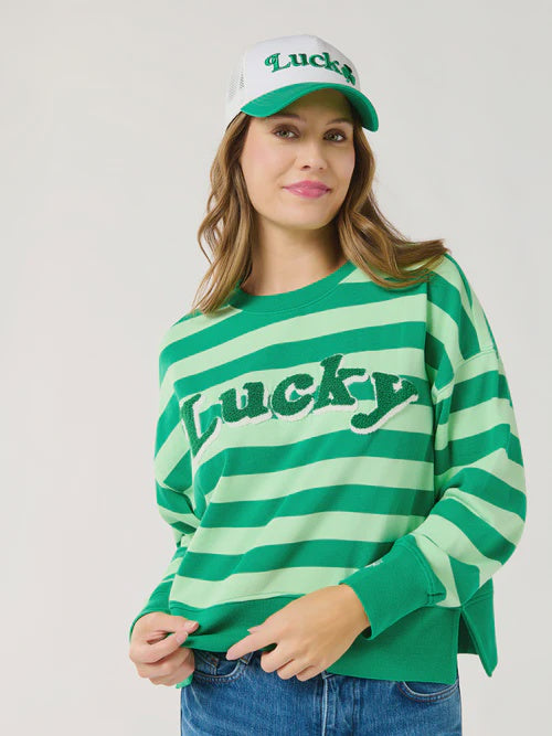 Digital photograph of a woman posing in a studio wearing a green striped St. Patrick&