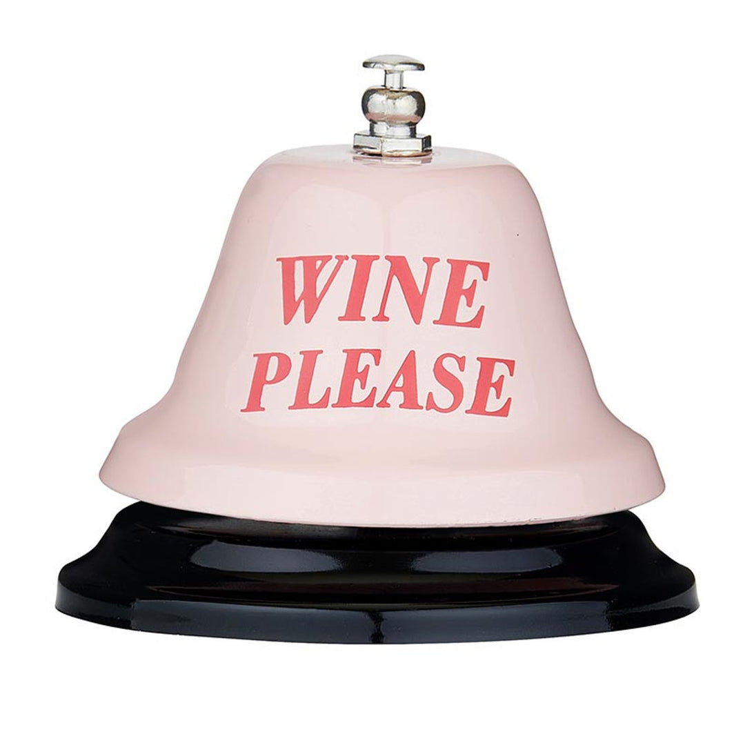Product photograph of a novelty service bell on a white background featuring a light pink dome with the text WINE PLEASE in red serif font atop a glossy black base and silver metallic ringer