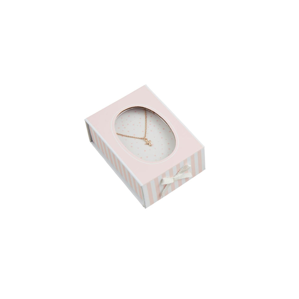 Studio photograph of a gold cross pendant necklace displayed in a pink and white striped gift box featuring a dainty white ribbon and a polka-dotted oval window against a white background