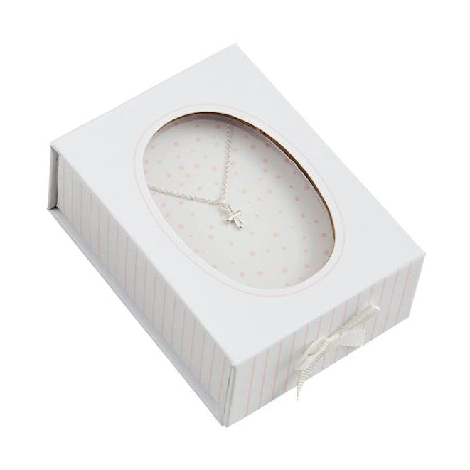 Studio photograph of a silver cross necklace resting inside a white and pink pinstriped gift box featuring an oval display window, a pink polka-dot interior lining, and a delicate white satin bow