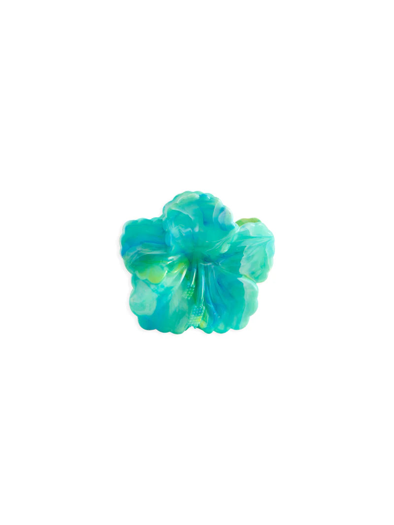 Acetate hair claw by Coucou Suzette featuring a marbled turquoise and emerald green hibiscus flower with a delicate yellow stamen centered on a plain white background