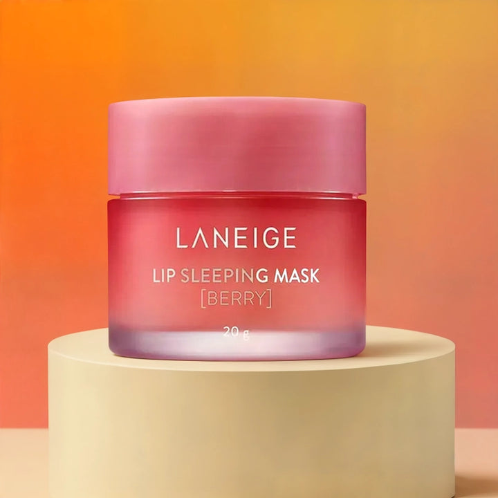 Commercial product photograph of Laneige featuring the Berry Lip Sleeping Mask on a cream pedestal against a warm orange gradient backdrop showcasing a pink frosted glass jar and white lettering
