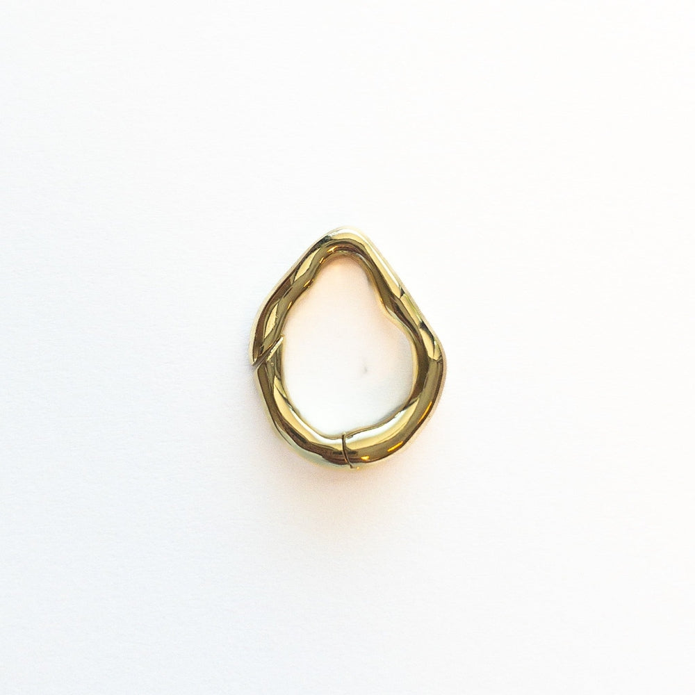 Polished gold metal jewelry component featuring an irregular organic ring centered on a minimalist white background with a fluid melted aesthetic and reflective mirror-like finish