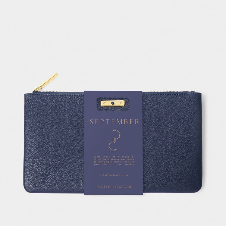 Pebbled faux leather pouch by Katie Loxton featuring a navy blue September birthstone clutch against a white background with a gold-tone zipper, textured finish, and a paper sleeve detailing lapis lazuli properties