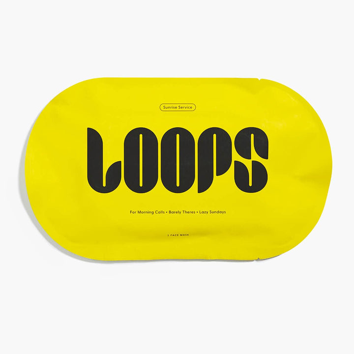 Graphic design product packaging by Loops featuring a bright yellow pill-shaped Sunrise Service face mask packet on a white background with the bold black stylized LOOPS logo and subtext regarding morning calls and lazy Sundays