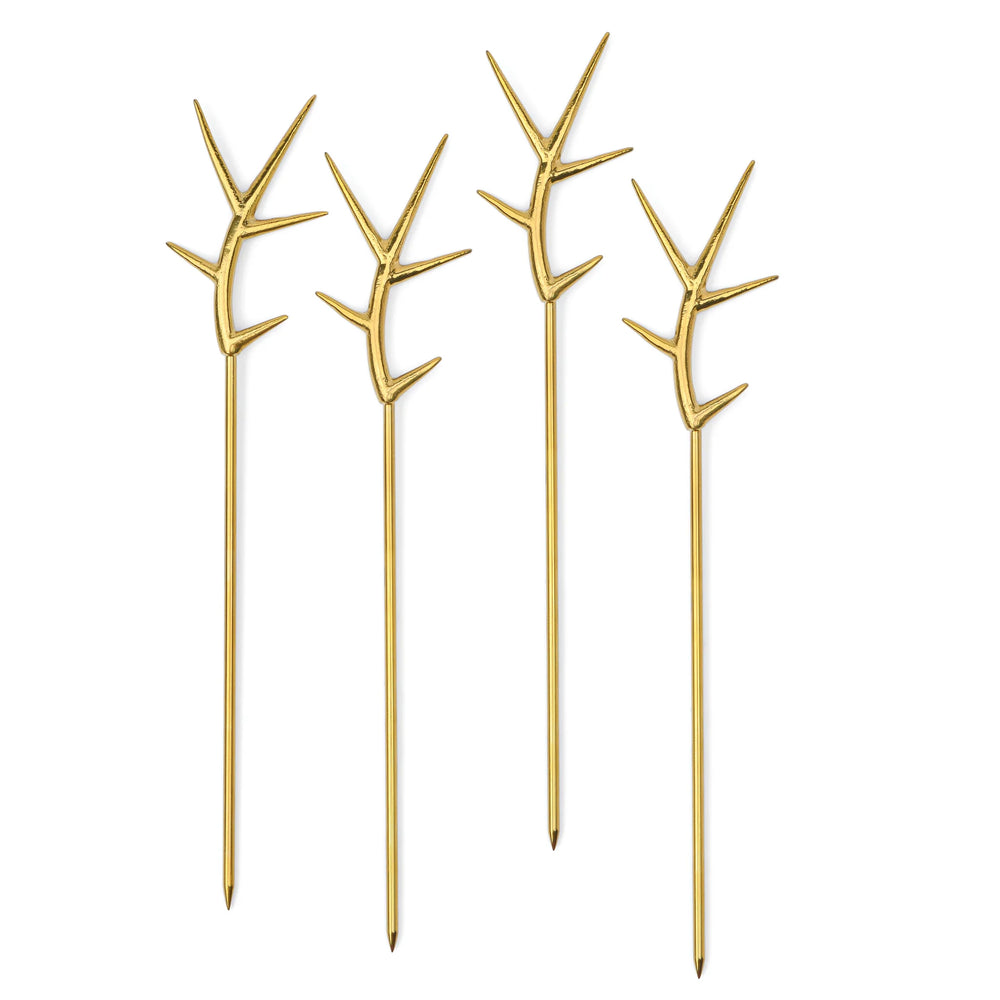 Gold-plated metal cocktail picks by Michael Aram showcasing a set of four skewers against a white background, featuring the signature branch-inspired handles with a textured gold finish and slender pointed tips