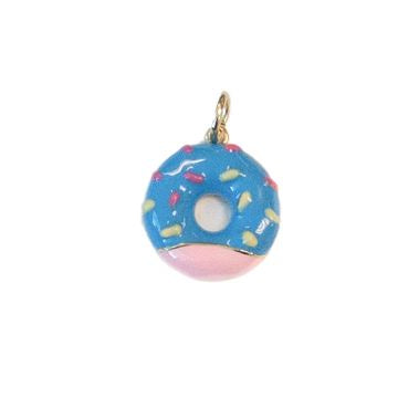 Enamel and gold-tone jewelry charm of a frosted donut centered on a white background featuring glossy blue icing, multi-colored sprinkles, and a light pink base