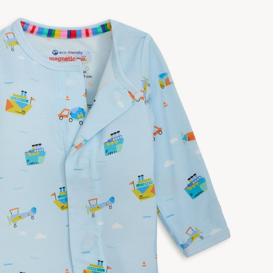 Eco-friendly fabric baby romper by Magnetic Me on a white background featuring a light blue pattern of yellow steamships and blue biplanes with a vibrant rainbow-striped inner neckline and a magnetic closure flap