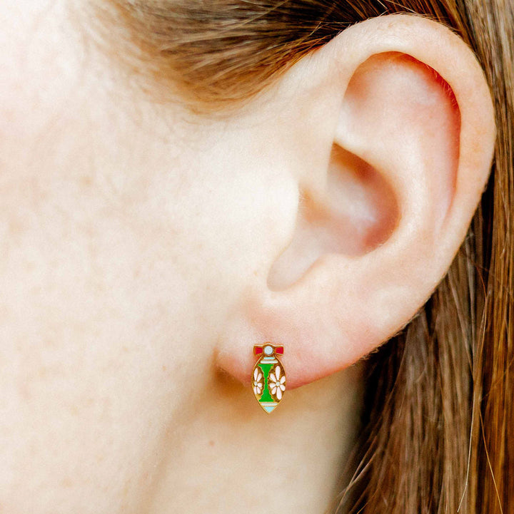 Photograph of an enamel stud earring depicting the Leaning Tower of Pisa on a person&