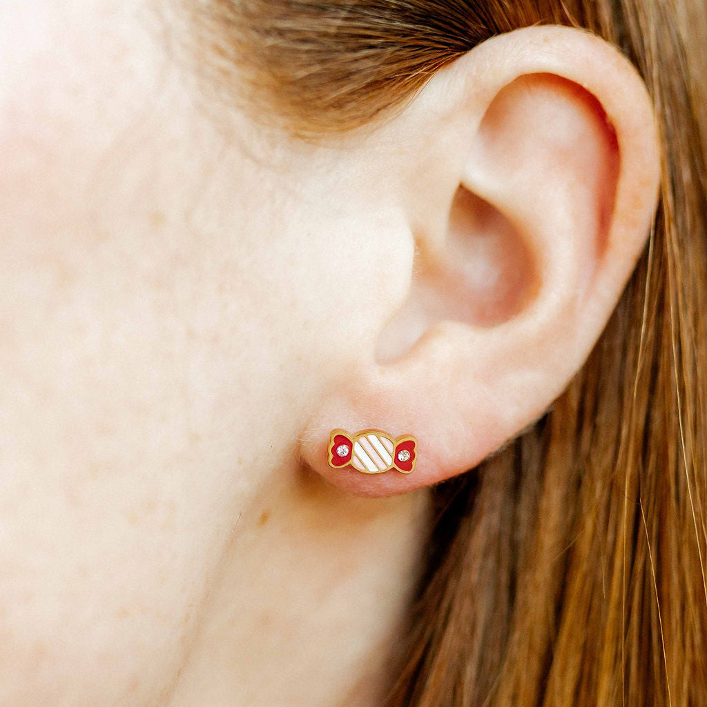 Photograph of a gold candy-shaped stud earring worn on a person&