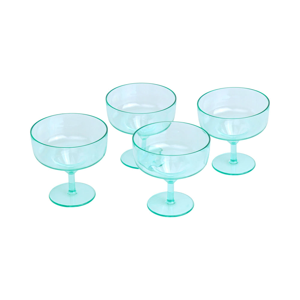 Glassware set of four mint green tinted coupe glasses on a white background featuring translucent aquamarine surfaces, wide circular bowls, and delicate stems