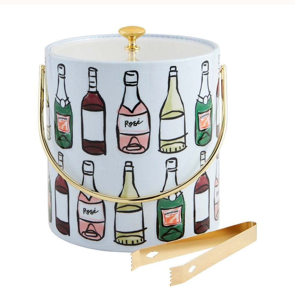 Kate Spade New York illustrated ice bucket on a white background featuring a whimsical pattern of colorful champagne and rosé bottles with a polished gold-tone handle and matching gold ice tongs