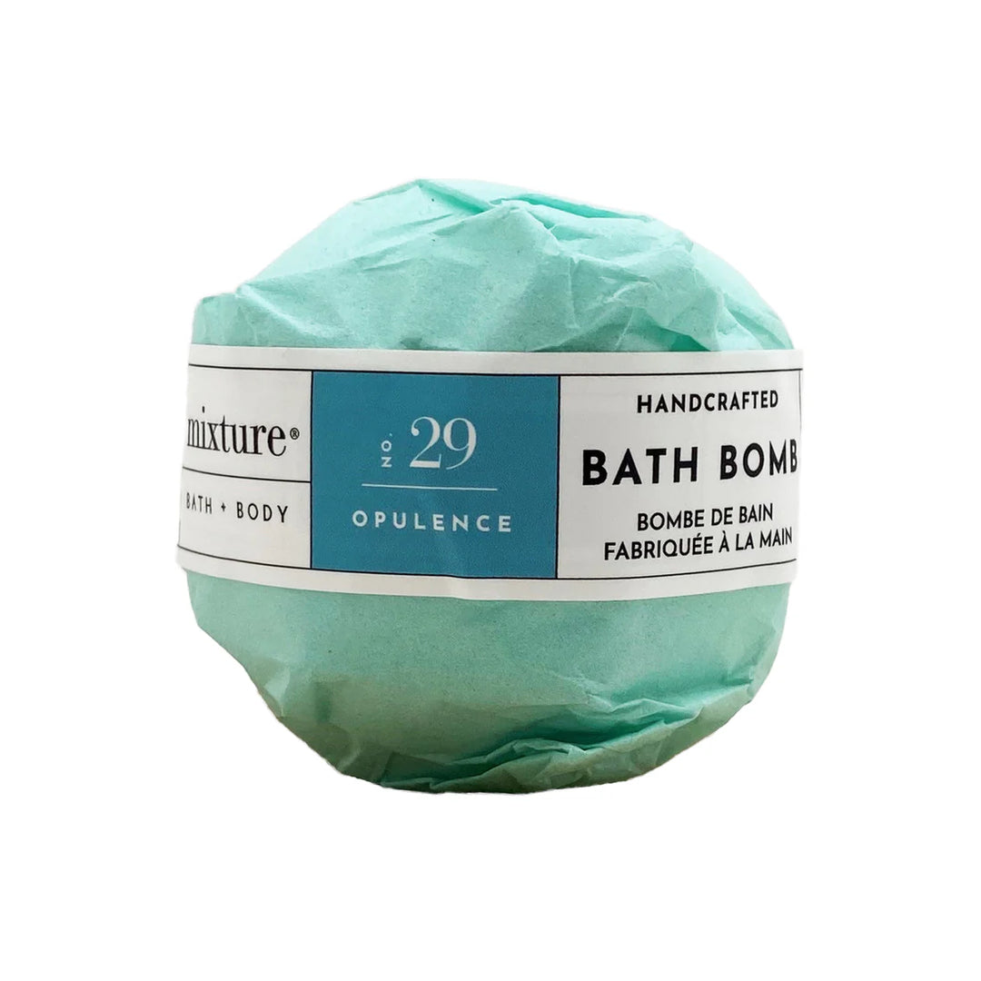 Mixture handcrafted bath bomb titled No. 29 Opulence is wrapped in textured light teal tissue paper and features a white band label with a central blue panel and bold black typography on a white background