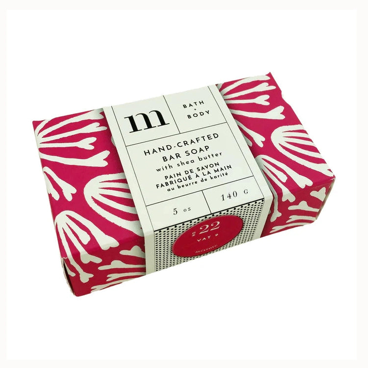 Photograph of Mixture brand hand-crafted bar soap with shea butter on a white background featuring a vibrant magenta wrapper with white botanical block prints and a red No 22 Vat 9 sticker