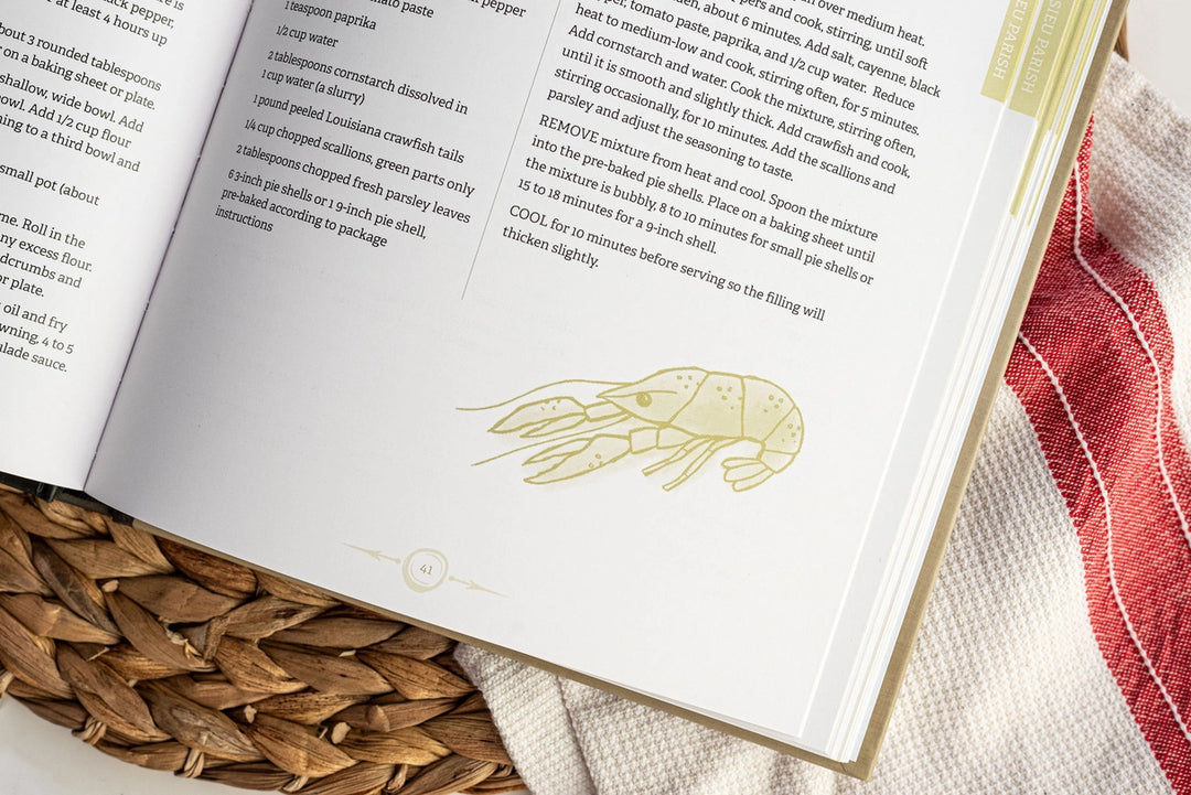 Printed cookbook page featuring a Louisiana crawfish recipe with a green line-art crawfish illustration, page number 41, and a red and white checkered cloth over a woven wicker basket