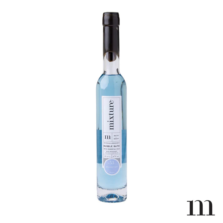 Product photograph by Mixture of a slender glass bottle of bubble bath on a white background featuring translucent pale blue liquid, minimalist vertical typography, and a sleek black cap