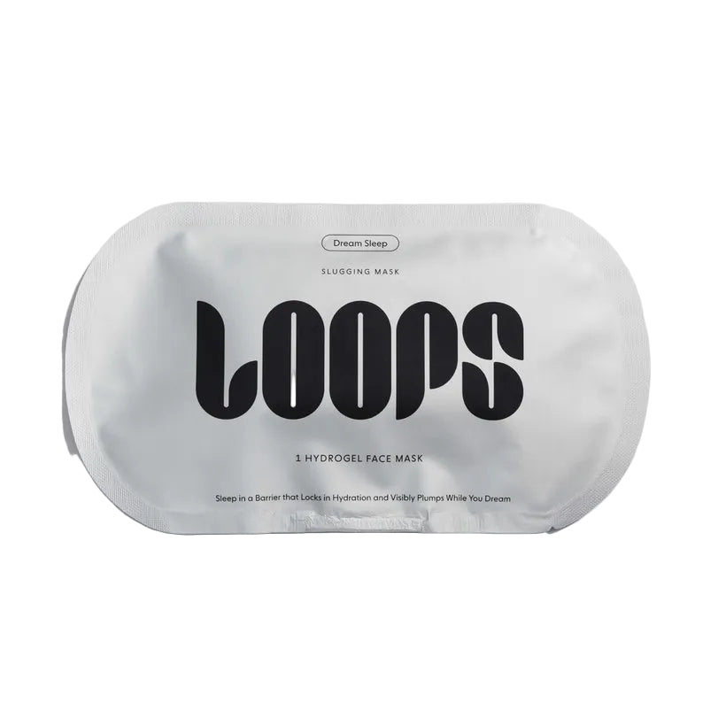 Product packaging by LOOPS Beauty showcasing a Dream Sleep Slugging Mask sachet against a white background featuring bold black stylized typography, a metallic silver-white finish, and a unique pill-shaped pouch design