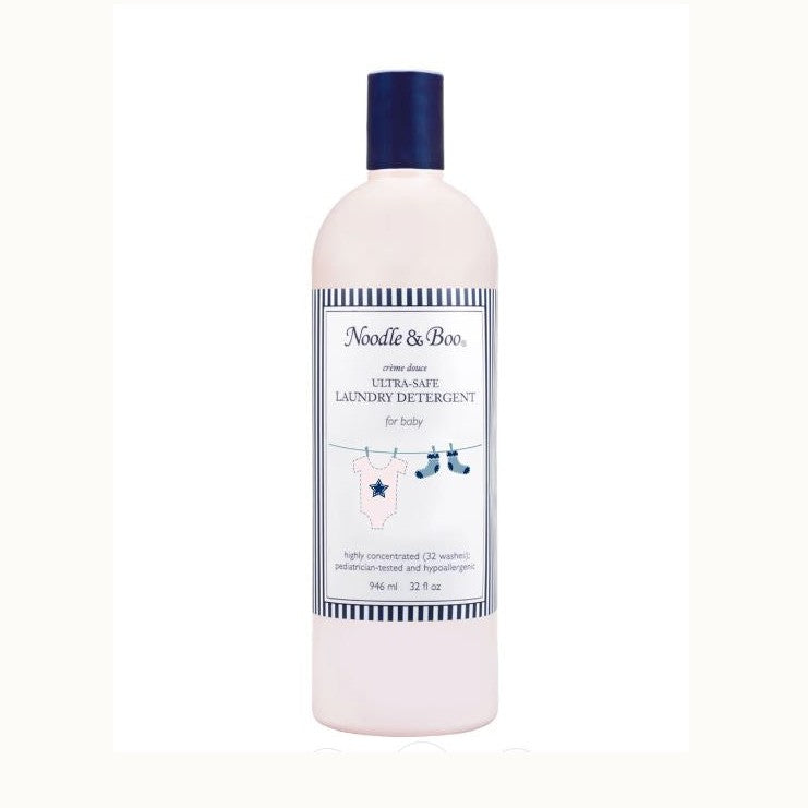 Product photograph of Noodle & Boo Ultra-Safe Laundry Detergent for baby featuring a soft pink bottle with a navy blue cap and a label illustrated with a pink star onesie and blue socks hanging from a clothesline