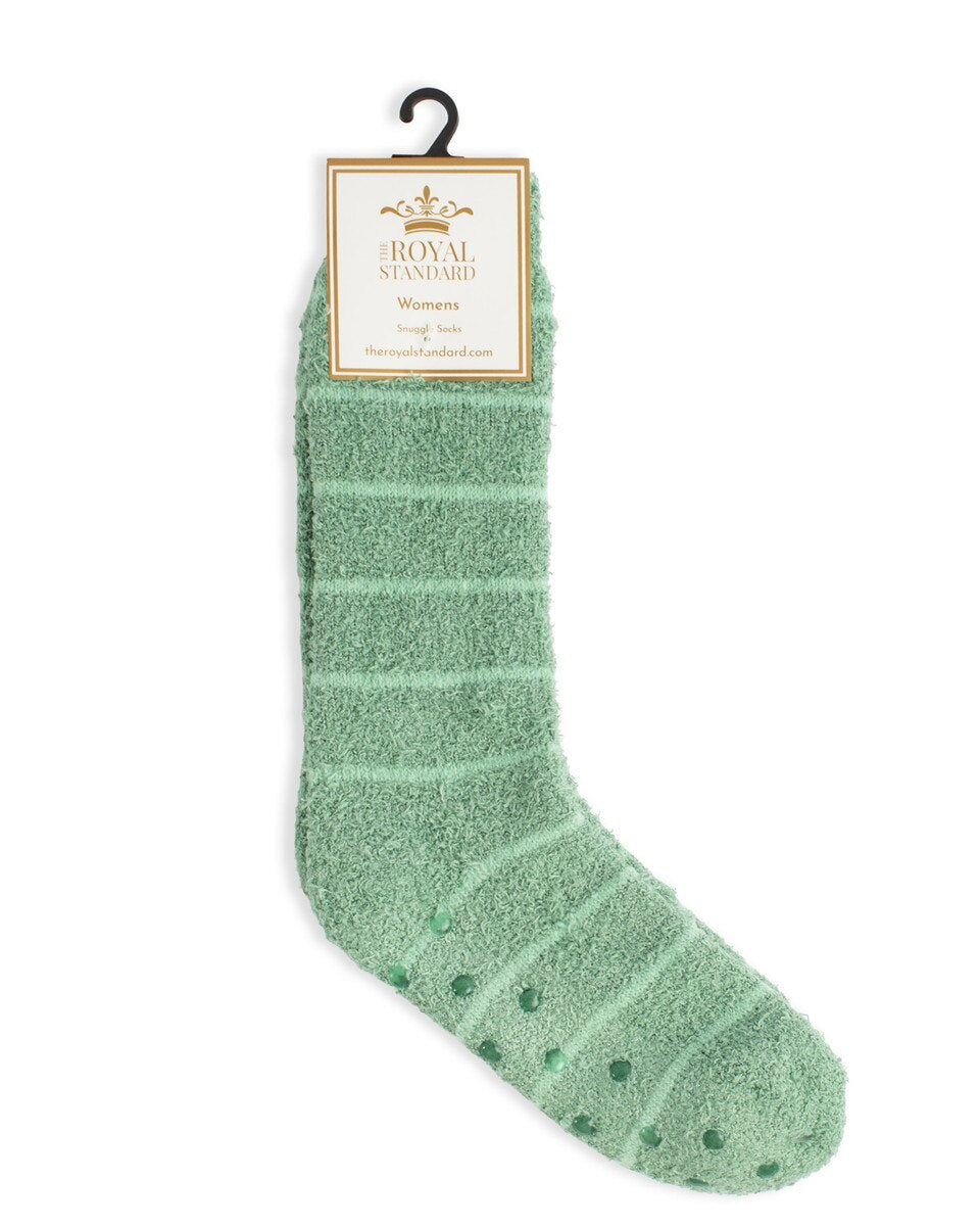 Product photograph by The Royal Standard of mint green fuzzy socks featuring horizontal stripes, non-slip rubber sole grippers, and a branded cream packaging tag against a white background