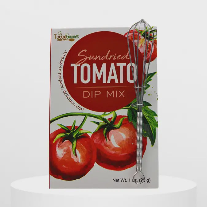 Product packaging by Too Good Gourmet of a Sundried Tomato Dip Mix box on a white pedestal featuring vibrant red vine tomatoes, a miniature stainless steel whisk, and bold white typography