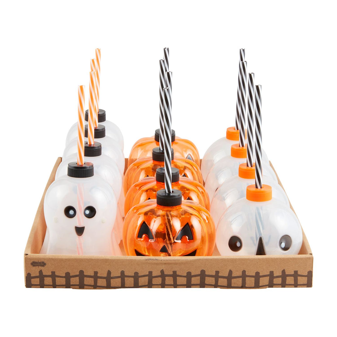 Commercial product photography by Mud Pie featuring ghost and jack-o'-lantern pumpkin sipper cups in a cardboard display tray against a white background, showcasing orange and black striped straws and a base decorated with a brown picket fence pattern