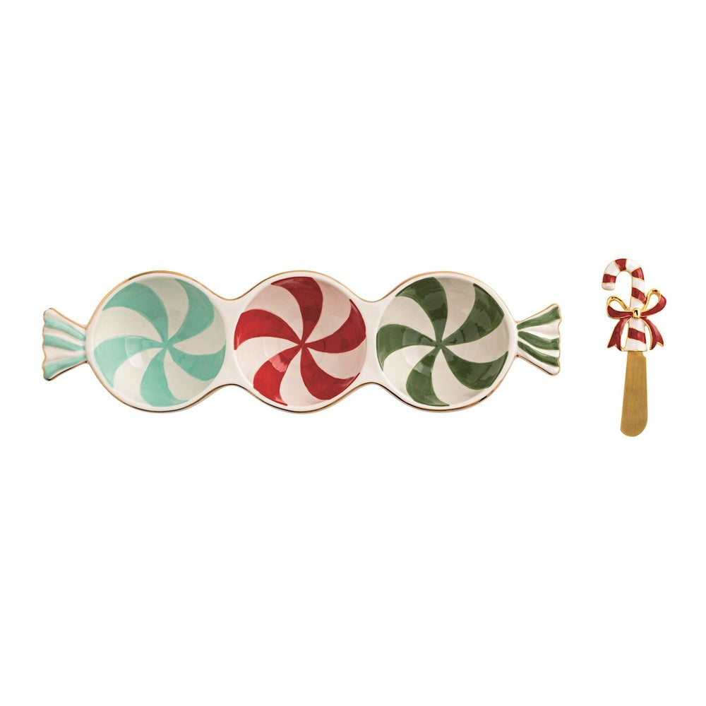 Ceramic peppermint serving set by Lenox featuring a three-sectioned candy-shaped dish on a white background with mint, red, and forest green swirl patterns, gold-trimmed edges, and a matching candy cane spreader with a red bow