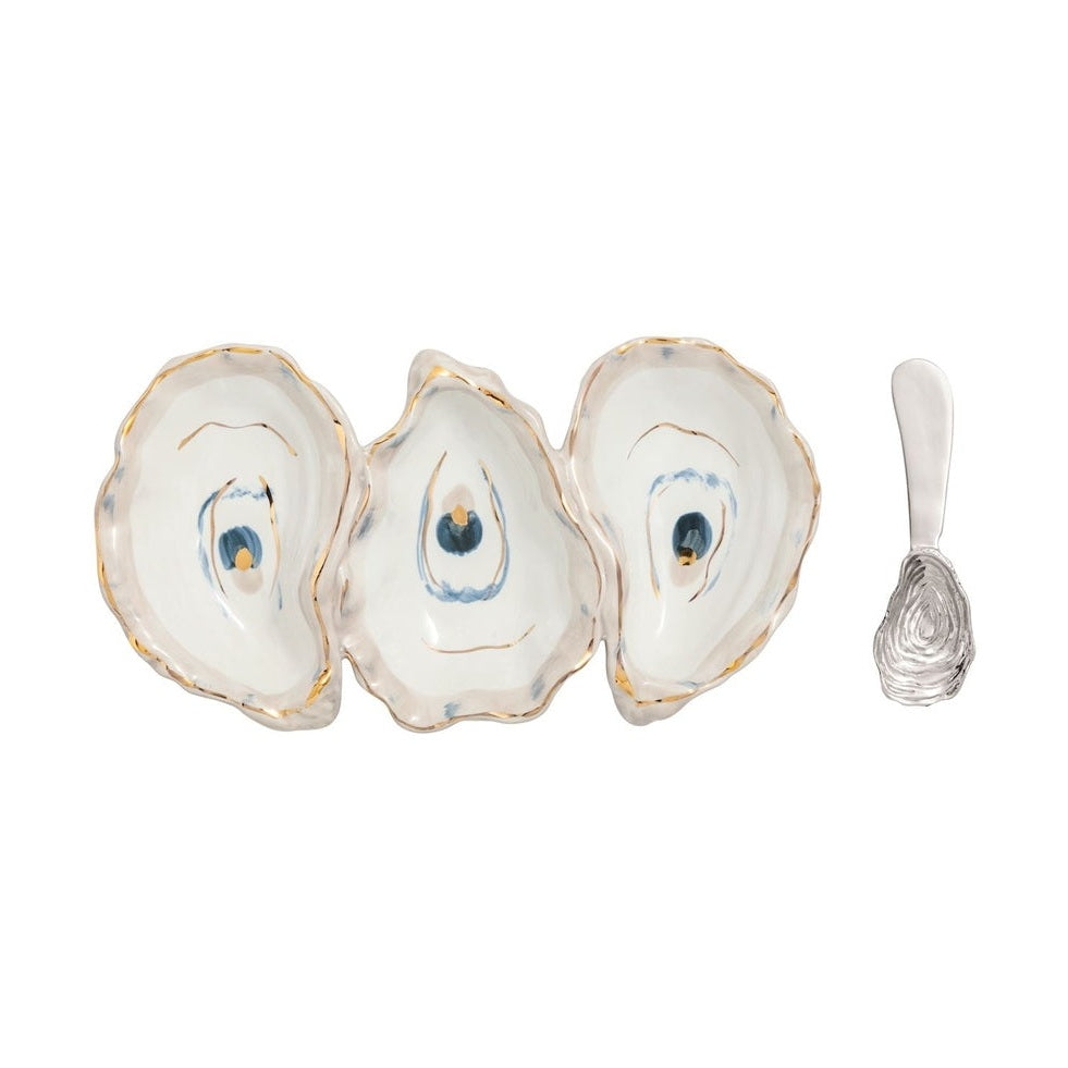 Stoneware serving dish by Aerin featuring three joined oyster shell compartments positioned on a white background with hand-painted gold-leaf rims, blue-hued interior accents, and a matching textured silver-tone oyster spoon