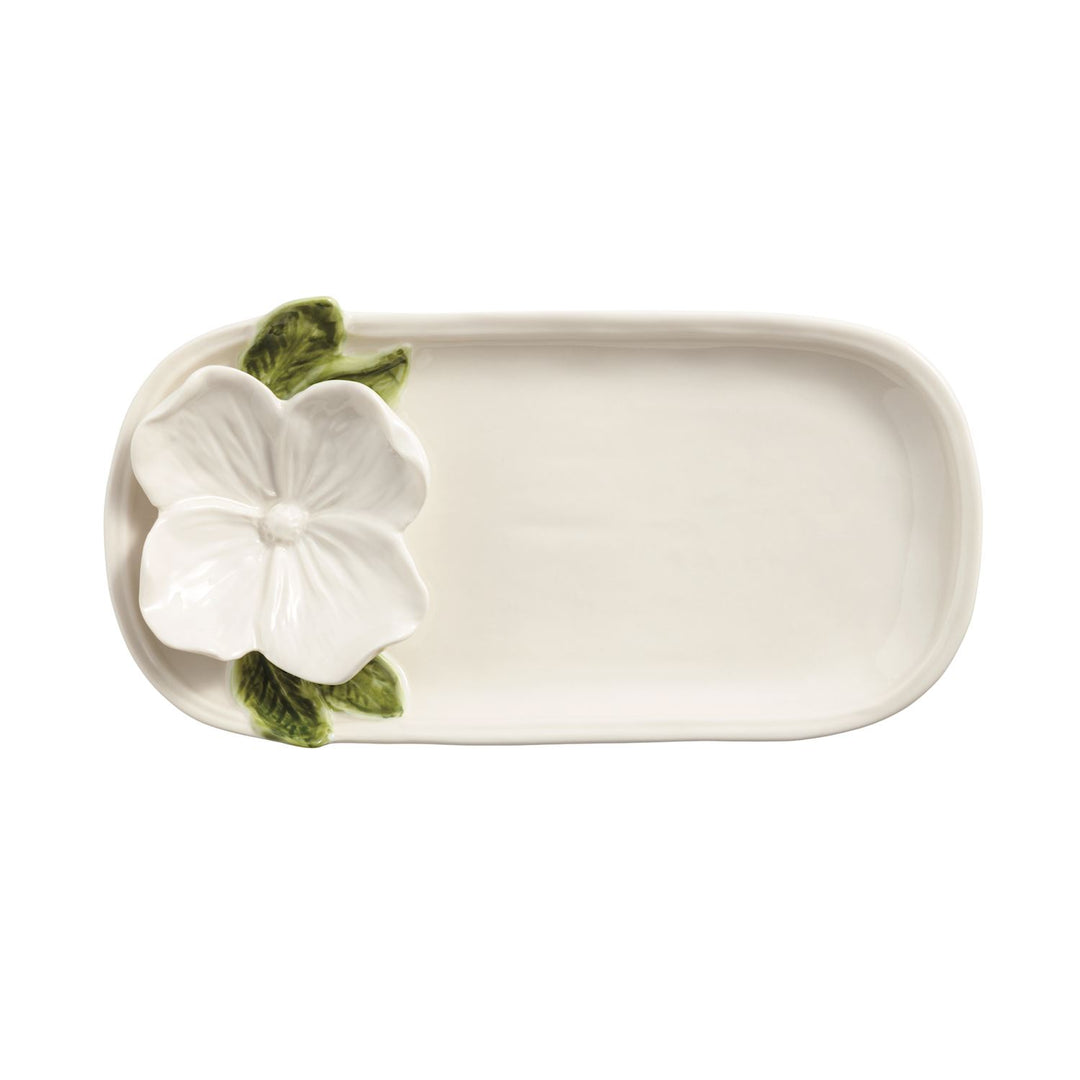 Ceramic platter by Vietri featuring a sculpted white hibiscus flower on a small rectangular tray with vibrant green leaves and a glossy cream finish