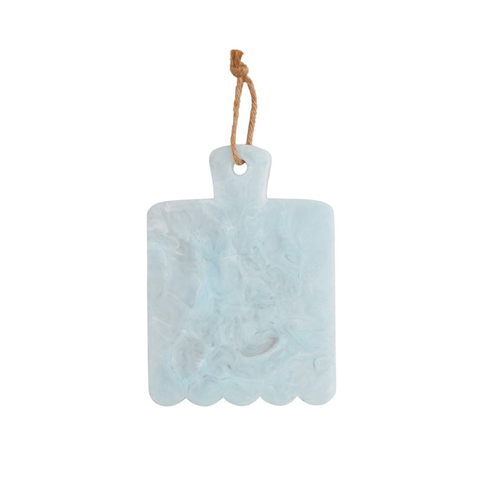 Marbled resin serving board by an artisan designer featuring a rectangular subject against a white background with translucent sky blue swirls, a scalloped bottom edge, and a rustic jute rope hanging loop