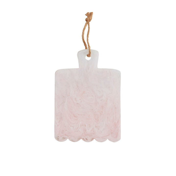 Hand-cast resin serving board featuring a pink and white marble swirl design with a unique scalloped bottom edge and a natural jute hanging loop isolated on a white background