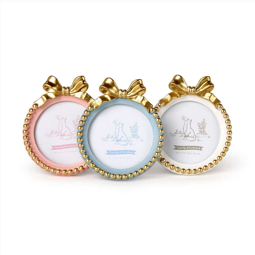 Resin photo frames by Cupcakes & Cartwheels featuring three circular frames in pastel pink, blue, and cream topped with decorative gold bows and finished with metallic gold bead trim along the circular borders