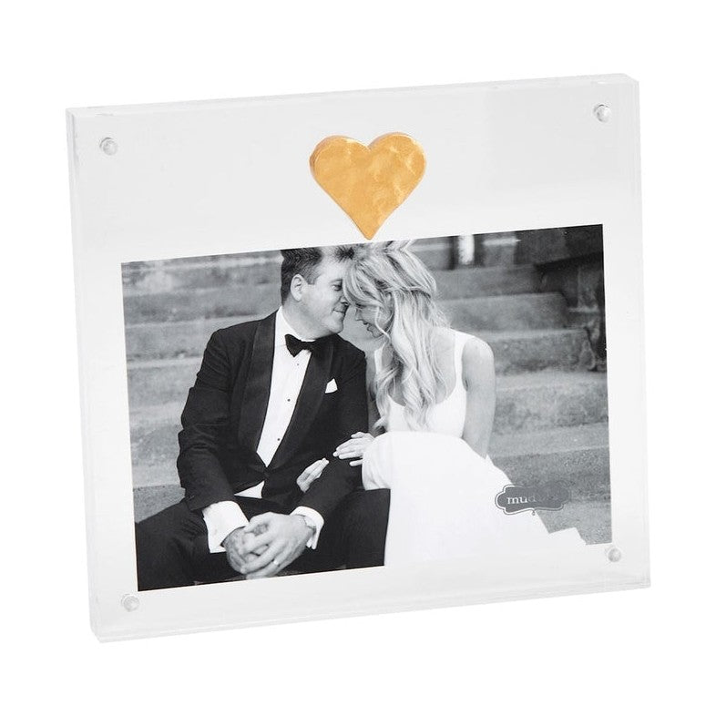 Acrylic magnetic picture frame by Mud Pie showcasing a black and white photograph of a bride and groom on stone steps featuring a hammered gold heart ornament and silver corner magnets