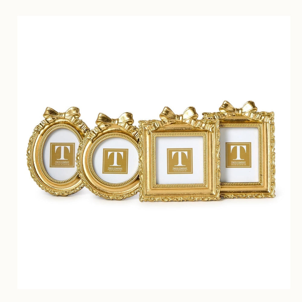 Gold resin picture frames by Two's Company featuring a set of four miniature frames on a white background with decorative bow-knot toppers, ornate beaded textures, and a variety of shapes including oval and rectangular