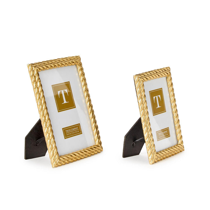 Sculpted gold-finished metal frames by Two’s Company featuring two rectangular picture frames with ornate rope-textured borders and black easel stands against a neutral white background