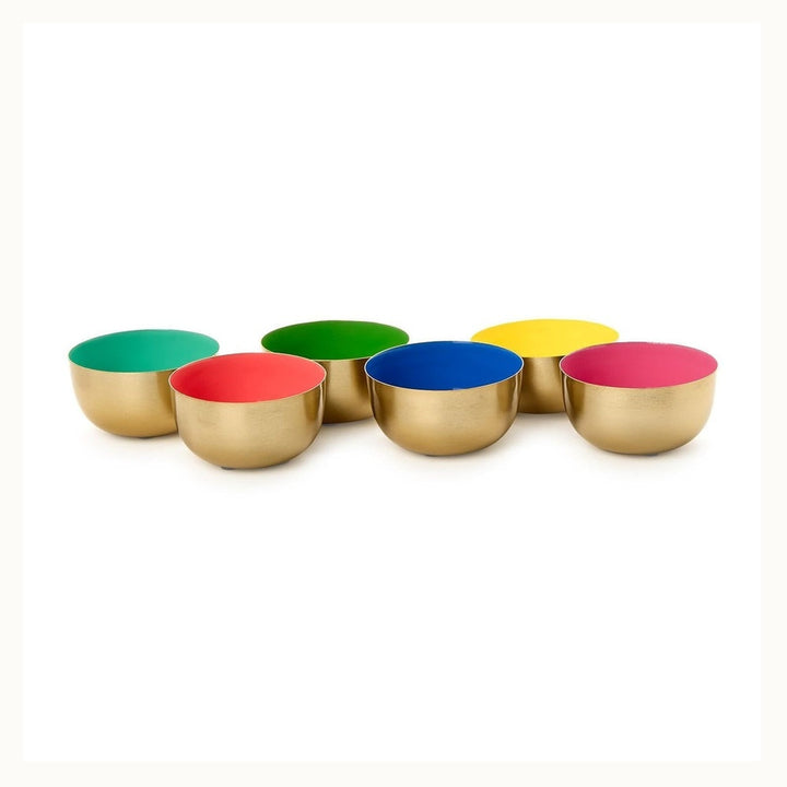 Enameled metal bowls by Herbert Krenchel featuring six small hemispherical vessels on a white background with brushed gold-tone exteriors and vibrant multicolored interiors in shades of pink, cobalt blue, and lime green