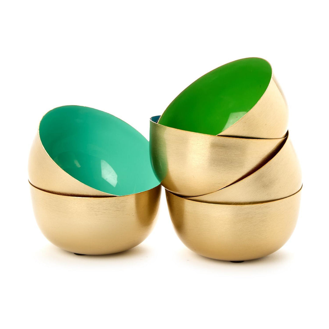 Brushed brass metal bowls displayed on a white background featuring a matte gold finish and vibrant teal and lime green enameled interiors