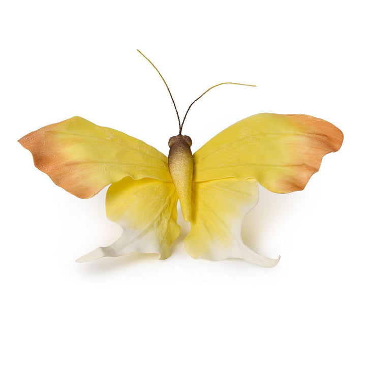 Fabric butterfly sculpture on a plain white background featuring gradient yellow wings with orange-brown tips and delicate white curled lower edges