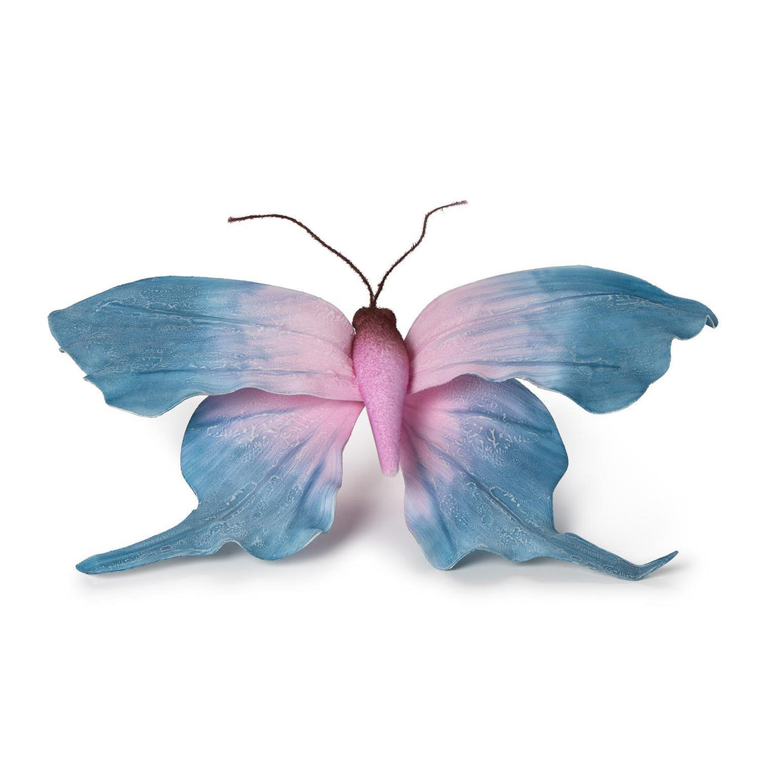 Fabric decorative butterfly ornament featuring a soft pink to dusty blue ombre gradient with realistic wing textures and dark brown wire antennae isolated on a plain white background