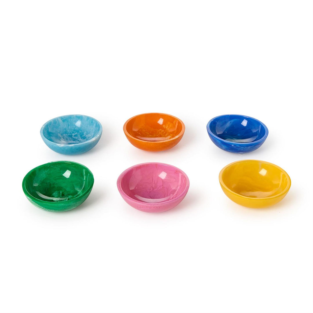 Hand-poured resin bowls by Dinosaur Designs arranged on a white background featuring unique marbled swirls, glossy finishes, and a vibrant palette of emerald green, bubblegum pink, and sunshine yellow