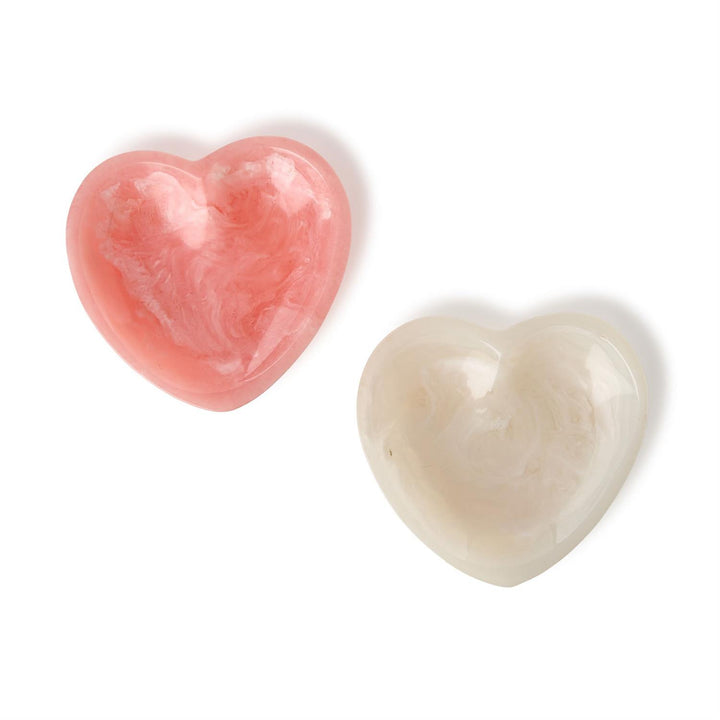 Resin decorative bowls featuring two heart-shaped trinket trays in marbled rose pink and creamy white tones on a white background with glossy finishes and smooth swirled patterns