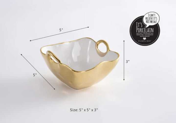 Porcelain square bowl by Pampa Bay featuring a gold titanium-plated exterior, white ceramic interior, and two ring handles displayed on a white studio background with 5-inch by 5-inch by 3-inch dimensions and the Pampa Bay brand logo