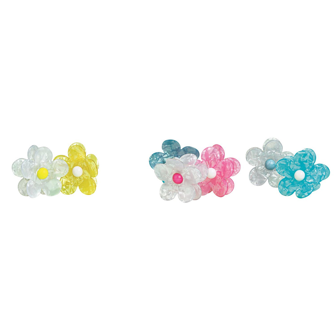 Studio photograph of acetate flower hair clips featuring an iridescent marbled finish and contrasting bead centers in pink and yellow against a minimalist white background