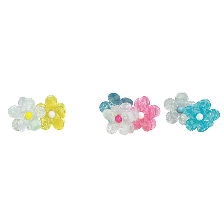 Studio photograph of acetate flower hair clips featuring an iridescent marbled finish and contrasting bead centers in pink and yellow against a minimalist white background