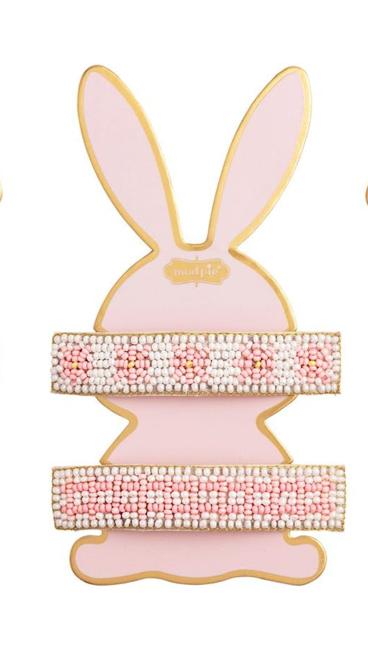 Beaded hair clips by Mud Pie displayed on a pink bunny-shaped card featuring intricate white and pink floral beadwork, horizontal striped patterns, and elegant gold-toned metallic edges
