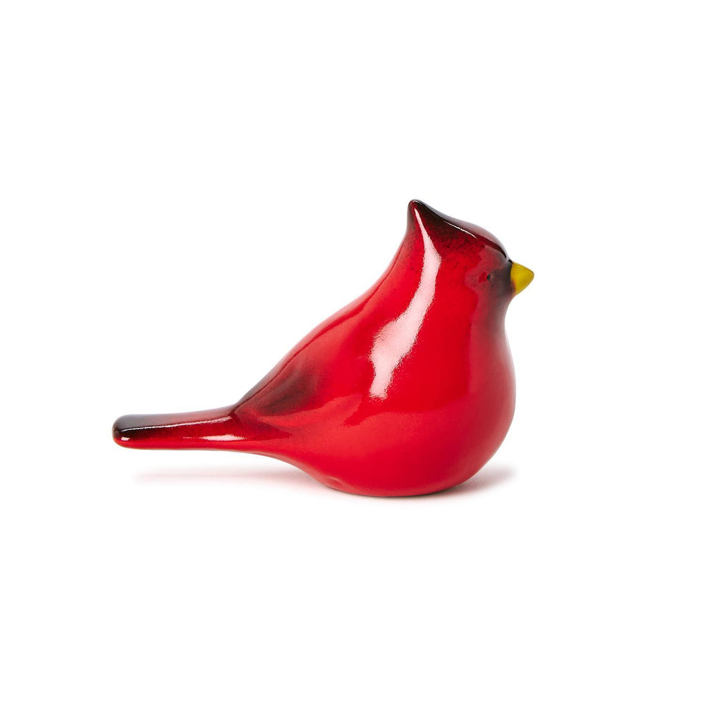 Hand-blown glass cardinal bird figurine positioned against a minimalist white background featuring a lustrous red body, a bright yellow beak, and subtle black accents on the crest and tail feathers