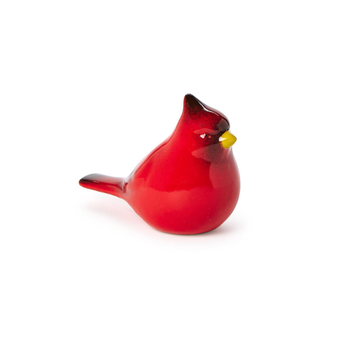 Glazed ceramic cardinal figurine set against a plain white background featuring a vibrant glossy red finish, a small yellow beak, and dark-tipped accents on its crest and tail