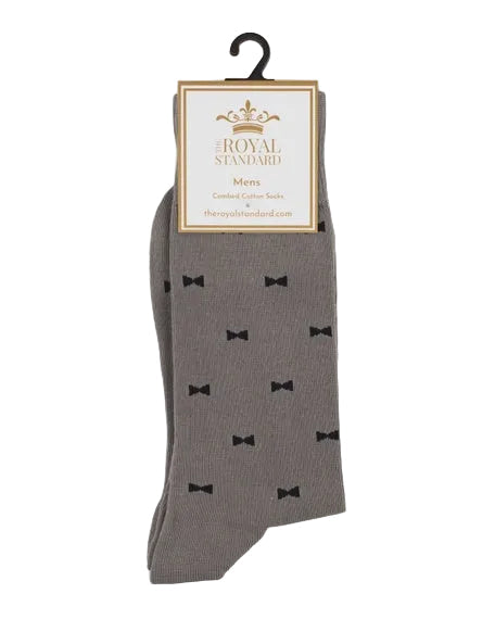 Combed cotton socks by The Royal Standard featuring men's charcoal grey dress socks with a repeating pattern of small black bow ties and a white brand tag with a gold crown logo on a white background